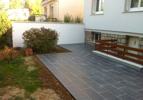 Terrasse extérieure en carrelage gris.